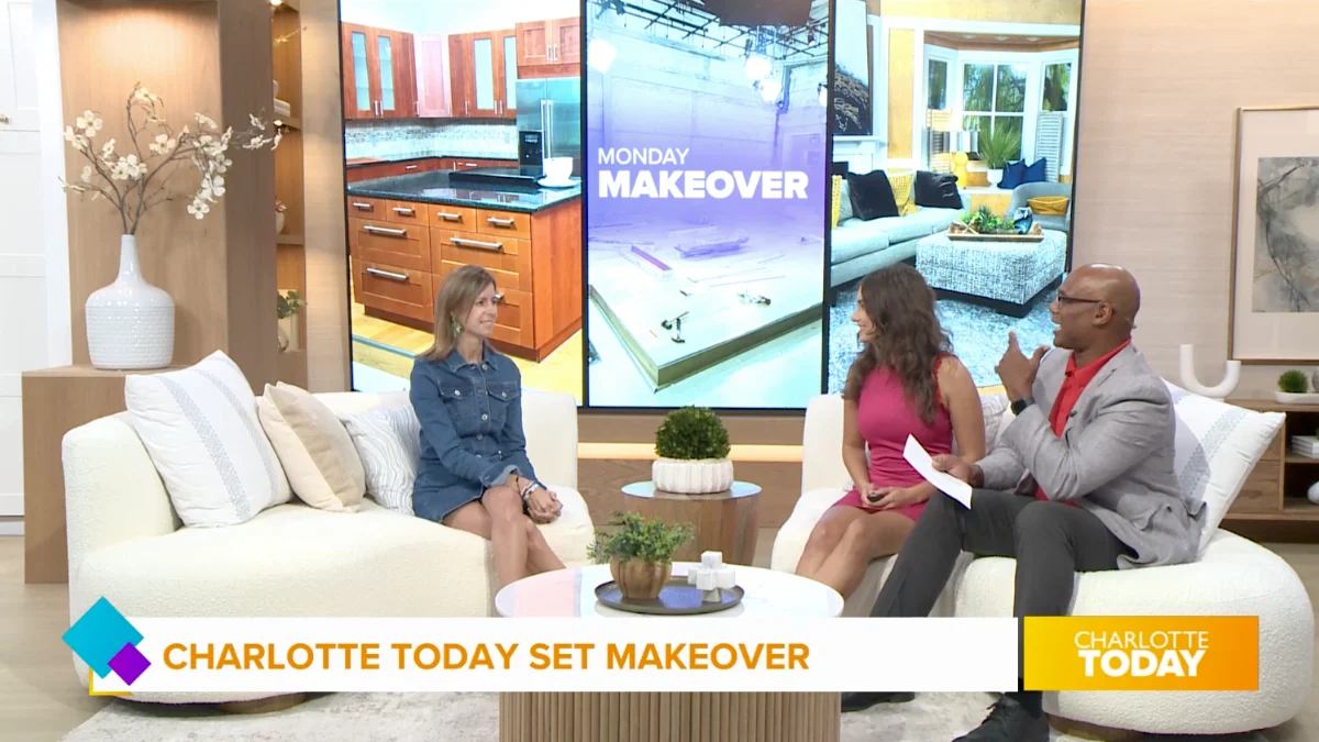 On a TV set, three hosts discuss a design segment, sitting in front of screens displaying before and after photos of kitchen and living room renovations.
