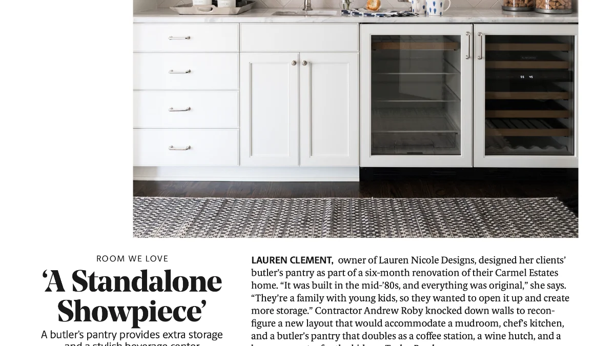 A screenshot of a website article showing white shaker cabinets form a butler’s pantry with a marble countertop, sink, and two integrated glass-front coolers for beverages and wine.