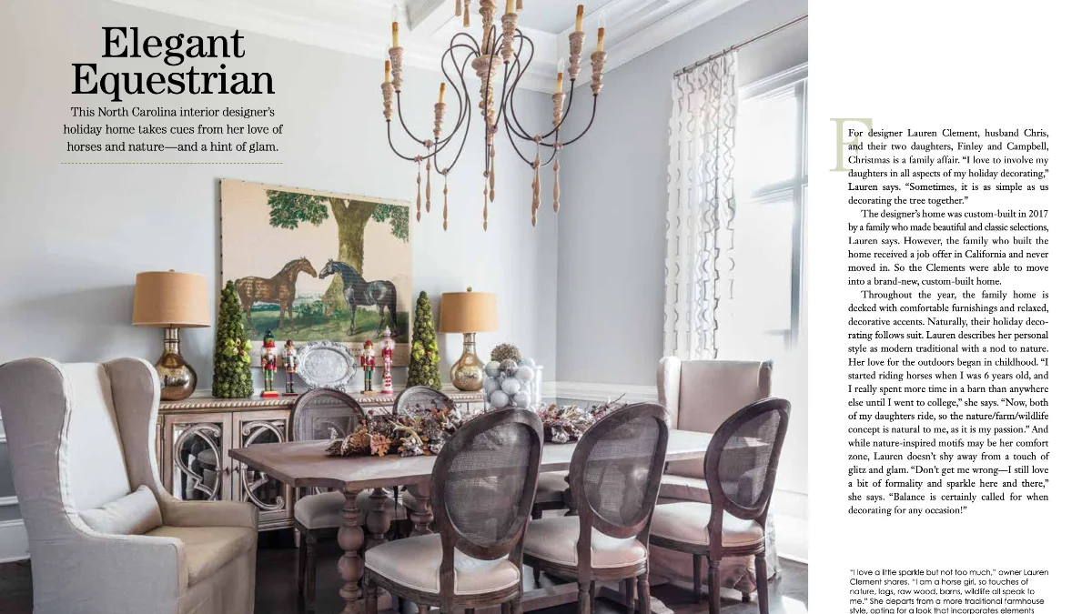 A two-page magazine spread of an elegant dining room decorated for the Christmas holidays. A wooden dining table and cane-back chairs sit below a rustic chandelier, facing a sideboard with nutcrackers and a large painting of two horses.